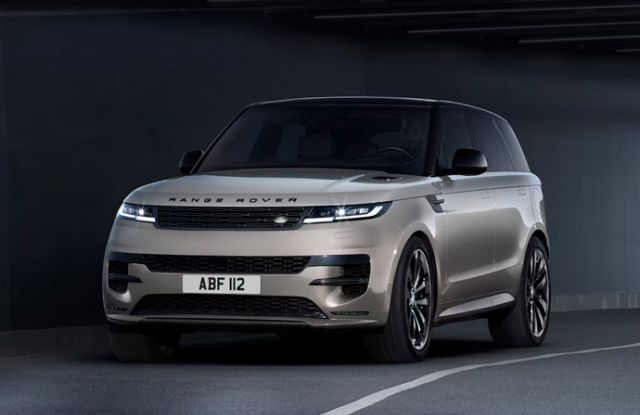 Champagne gold Range Rover Sport parked in a modern, dimly lit underground parking garage.