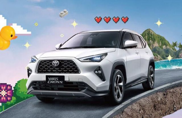 White Toyota Yaris Cross SUV driving on a coastal road, surrounded by playful pixel art and tropical scenery.