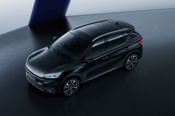 A top-down view of a black SUV, likely a BYD model, displayed in a minimalist studio with a dark floor and a contrasting blue and white background, highlighting its sleek design.