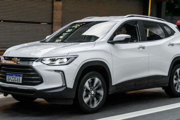 A white Chevrolet SUV driving on a city road, with a license plate "GFZ-2265" and urban buildings in the background.