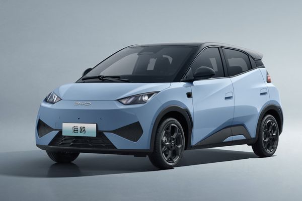 A light blue BYD electric car, highlighting its sleek front design, distinctive black wheels, "BYD" branding, and modern styling, set against a minimalist gray background.