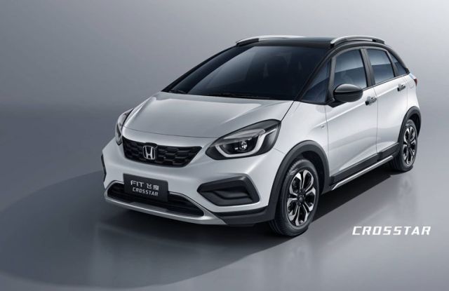 White Honda Fit CROSSTAR: Features Honda logo, "FIT 飞度 CROSSTAR" badging, black alloy wheels, and crossover-style trim—displayed against a gray background, showcasing its modern, rugged hatchback design.