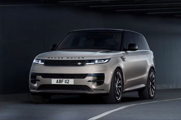 Champagne gold Range Rover Sport parked in a modern, dimly lit underground parking garage.