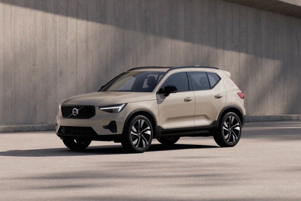 2025 Volvo XC40: sleek side design, black alloy wheels, parked by concrete wall under soft lighting.