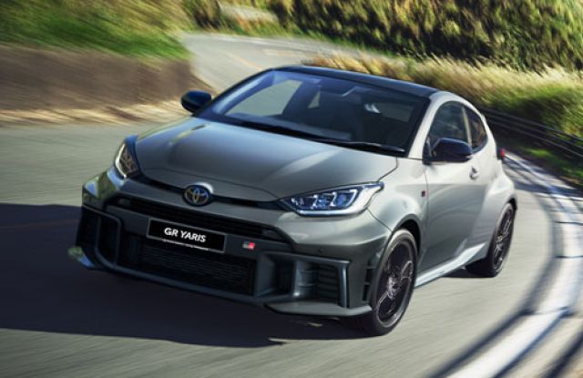 Gray Toyota GR Yaris (in motion on a curvy road): Features "GR YARIS" badging and sporty design, capturing its dynamic performance aesthetic in a scenic setting.