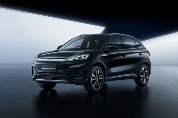 Front-three-quarters view of a black BYD Atto 3 SUV: sleek LED headlights, "BYD ATTO 3" badging, and alloy wheels. Set against a modern, lit background, it highlights the vehicle’s contemporary, polished design.