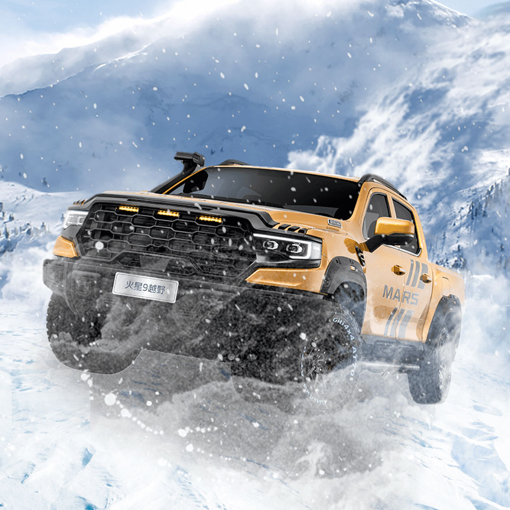 A yellow off - road pickup truck driving on snowy terrain with a mountainous background.