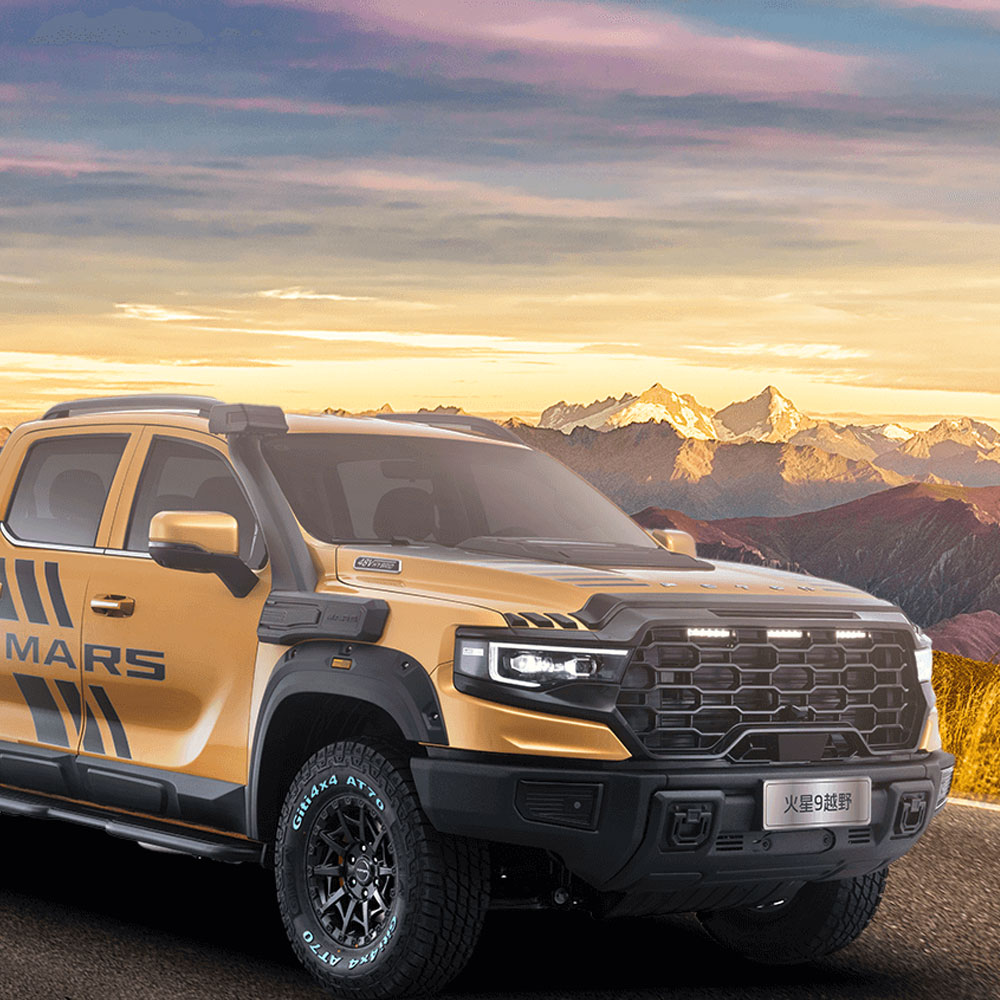 A yellow off - road pickup truck with "MARS" logo parked on a road, with majestic mountains and a colorful sky in the background.