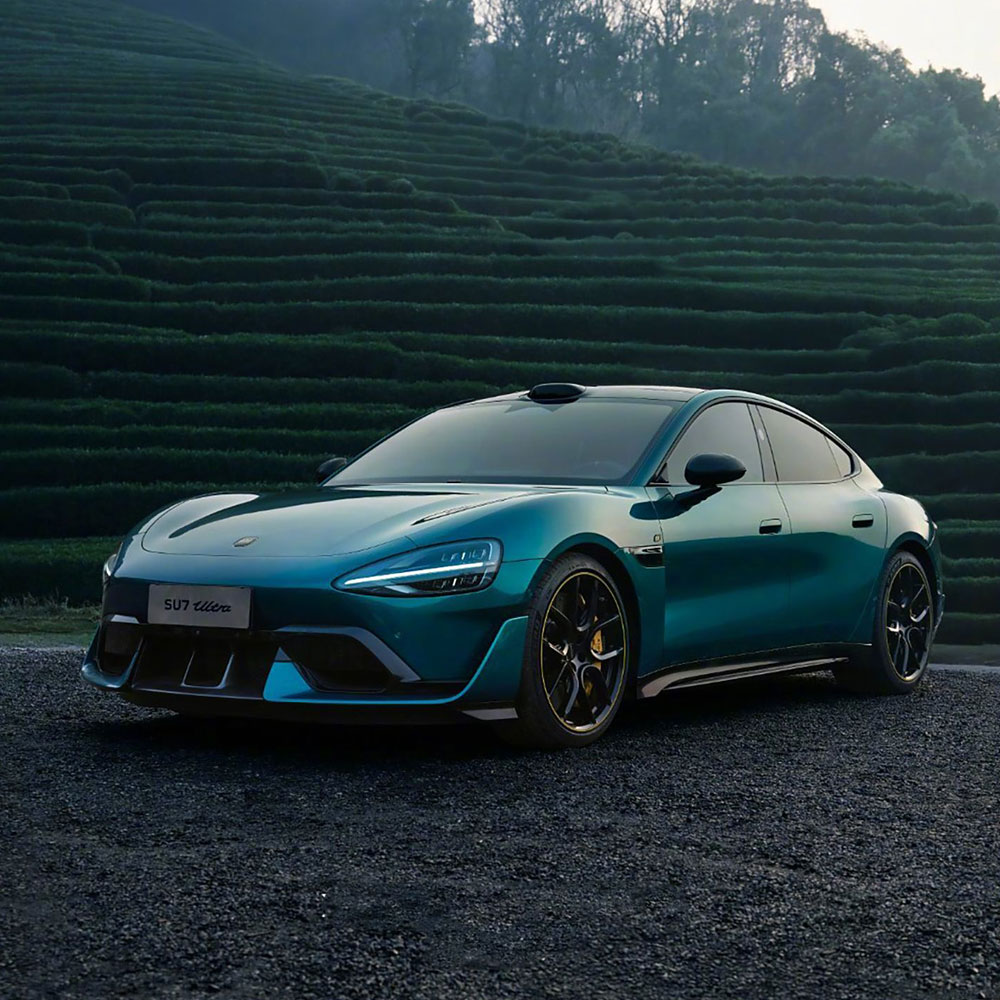 A teal SU7 Ultra car parked on a gravel road with a terraced green hillside in the background.