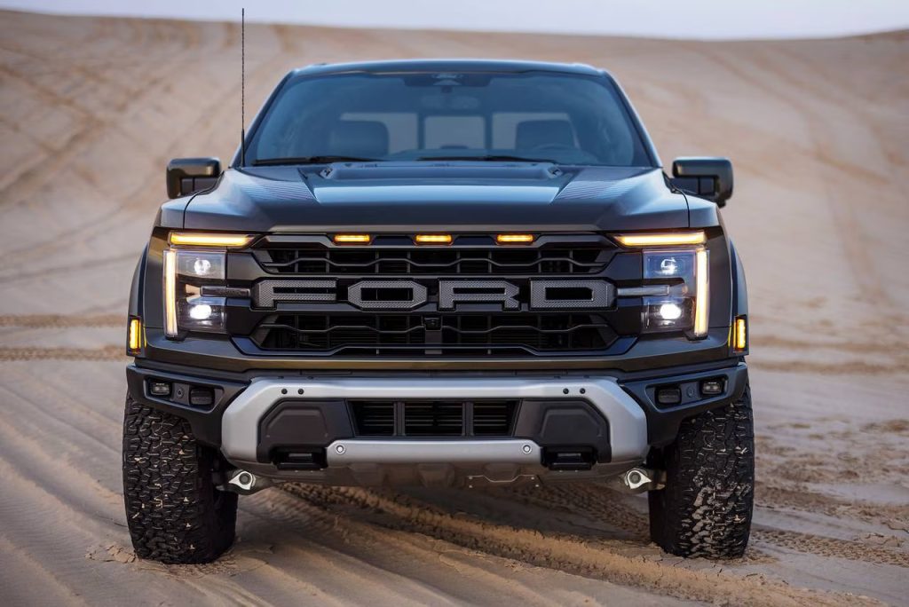 Front view of a Ford truck in a desert landscape, showcasing its rugged design and prominent front grille.