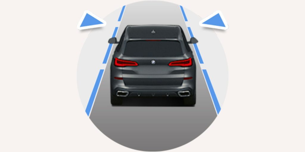 Rear view of gray 2025 BMW X1: centered in lane, flanked by blue directional arrows—simplified driving graphic.