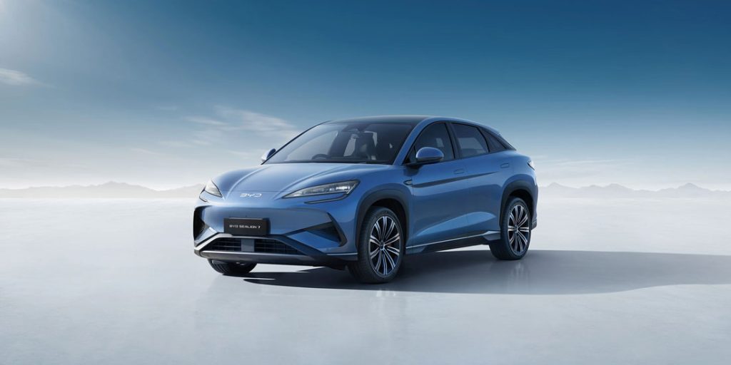 Blue BYD Seal N SUV displayed against minimalist light-blue background with distant mountain silhouette.