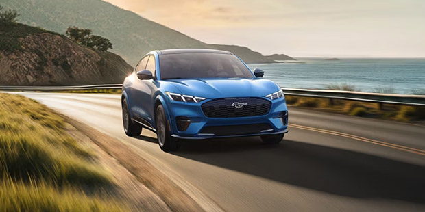 2025 Ford Mustang Mach-E driving down coastal highway