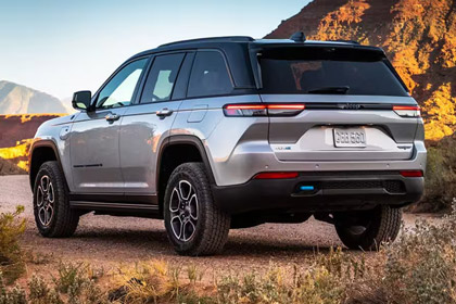 Rear three-quarter view of a silver 2025 Jeep Grand Cherokee Trailhawk 4xe
