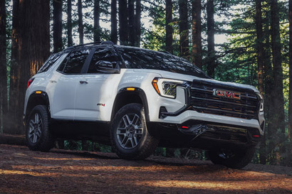 Front Three-Quarter View of the 2026 GMC Terrain AT4 Small Off-Road SUV Driving Through the Forest