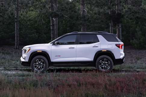 Profile View of the 2026 GMC Terrain AT4 Small Off-Road SUV Driving Through the Forest