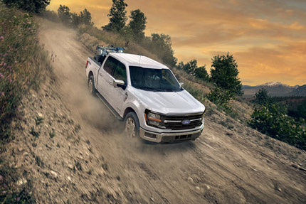2026 Ford F-150 FX4 model being driven down a steep slope on a dirt road