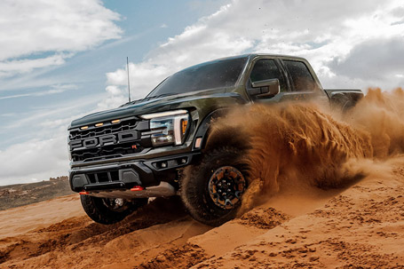 2026 Ford F-150 Raptor R truck kicking up sand while being driven in the desert