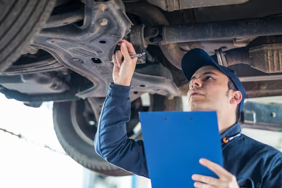 Mechanic inspects used car chassis