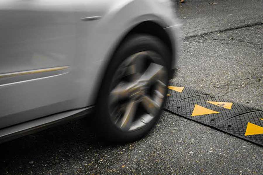 Cars drive over speed bumps on one side